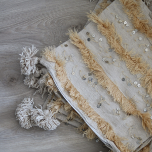 les housses de coussin Handura Agadir sont a plat sur un parquet en bois naturel ce qui fait ressortir son tissu beige 100% naturel